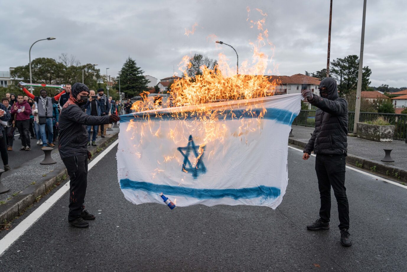 Vermummte verbrennen israelische Flagge bei Demonstration (am 11. November in Frankreich) nach dem Terror der Hamas in Israel und dem Krieg in Palästina / Gaza erlebt Frankreich erneut Antisemitismus, Quelle: picture alliance/dpa, Javi Julio, zumapress.com