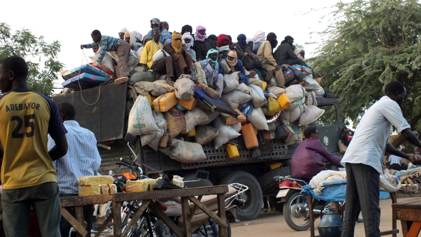 Migranten sitzen auf einem Lastwagen, der die Stadt Agadez in Niger verlassen will, 27. April 2015. Von hier aus müssen sie auf ihrem Weg nach Europa die Sahelwüste in Richtung Libyen oder Algerien durchqueren. Bild: Ali Abdou/dpa (zum Weltflüchtlingstag am 20.06. - zu dpa "Durch die Wüste nach Europa - Ein Menschenhändler erzählt" vom 18.06.2015) ++