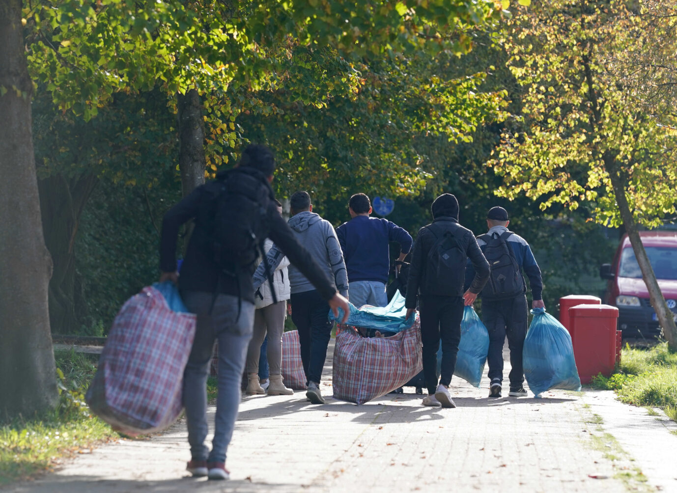 Auf dem Foto laufen mehrere Asylbewerber mit vollen Tüten und Koffern durch die Straßen von Hamburg. (Symbolbild)