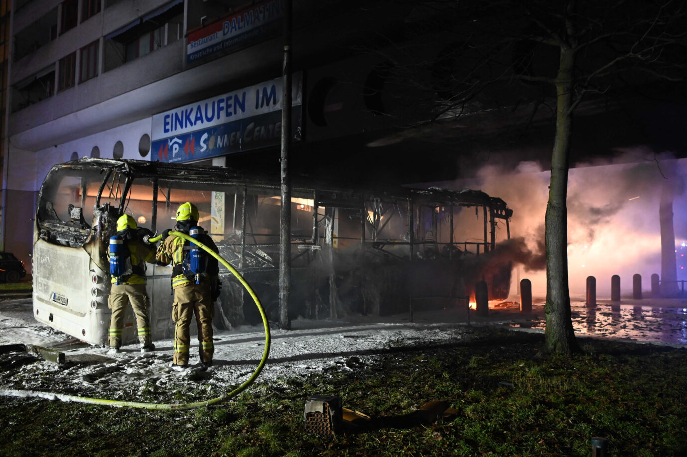 Einsatzkräfte der Berliner Feuerwehr löschen einen von Randalierern angezündeten Bus in Neukölln: Viele Migranten unter den Festgenommenen.