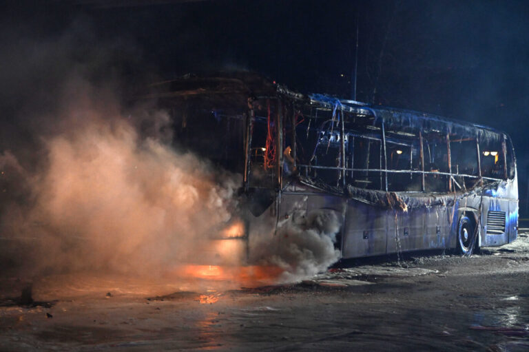 Einsatzkräfte der Feuerwehr löschen in der Silvesternacht an der Sonnenallee im Bezirk Neukölln einen brennenden Bus, der von Unbekannten angezündet worden war.