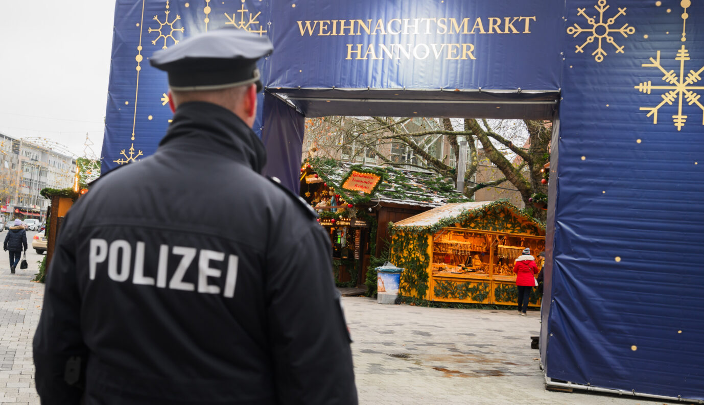 Ein Polizist steht am Weihnachtsmarkt. Die Ermittlungen gegen einen in Niedersachsen festgenommenen 20-Jährigen, der einen Terroranschlag in der Weihnachtszeit geplant haben soll, dauern an.