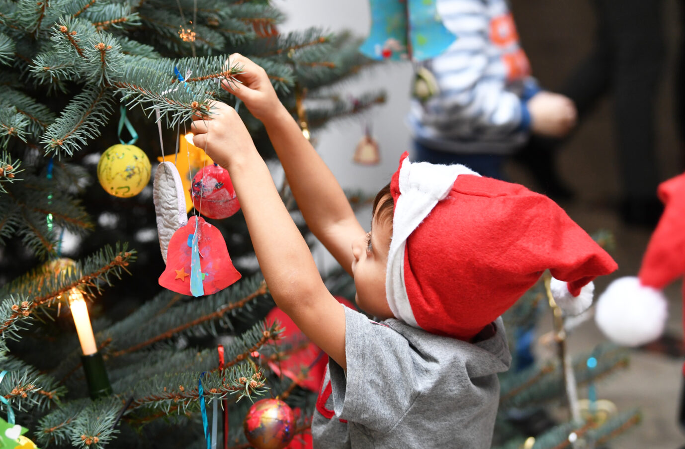 Ein Kind schmückt einen Weihnachtsbaum. In Hamburg-Lokstedt wird es dieses Jahr damit wohl nichts