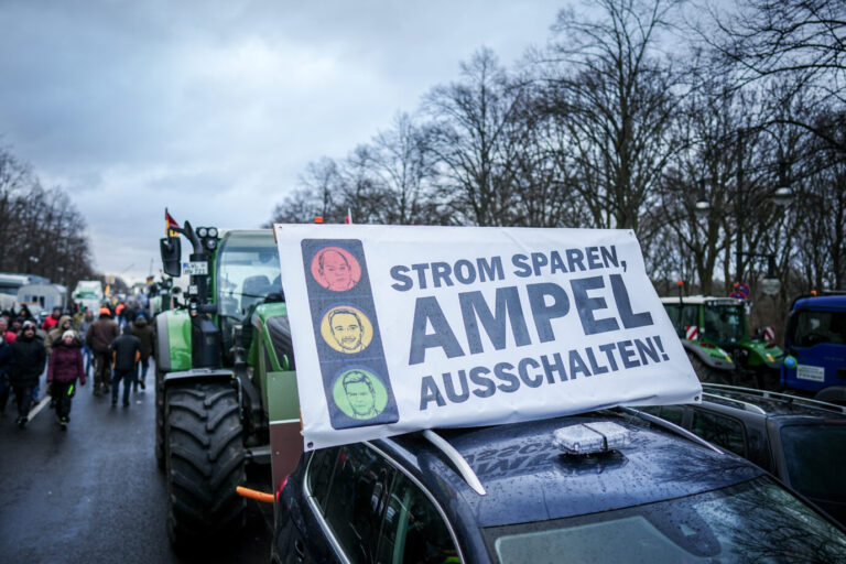 Auf dem Foto befindet sich ein Traktor mit einem Transparent auf einer Bauerndemo gegen die Politik der Ampel in Berlin. Auf dem Transparent steht "Strom sparen, Ampel ausschalten". (Themenbild/Symbolbild)