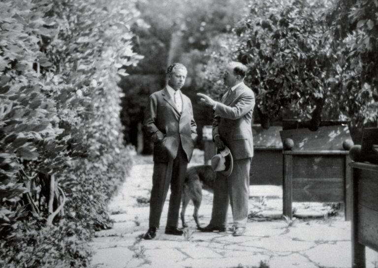 Max Reinhardt (l.) und Hugo von Hofmannsthal unterhalten sich im Park von Schloß Leopoldskron in Salzburg um 1920.
