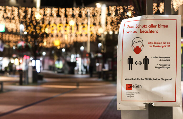 Auf dem Foto befindet sich ein Plakat mit Corona-Regelungen in Gießen. (Themenbild/Symbolbild)