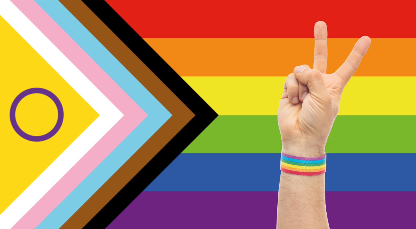 Eine Hand vor einer Regenbogenfahne formt ein Peace-Zeichen: Eine selbsterklärte Trans-Person erhält ein mildes Urteil für den Besitz von Kinderpornographie.