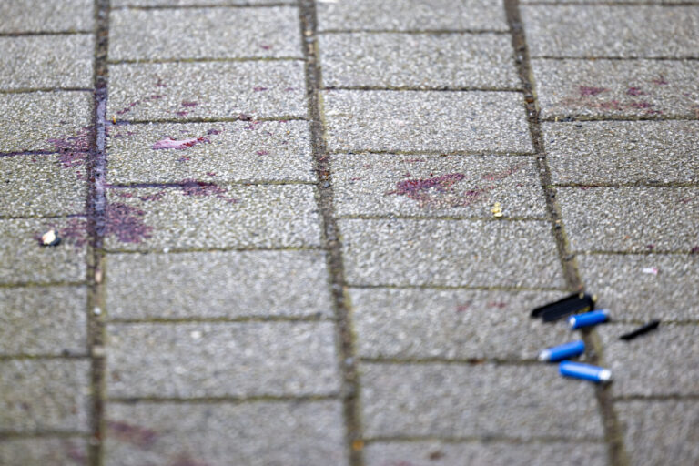 Blutspuren der verletzten Kinder auf dem Boden am Tatort des Angriffs in Duisburg auf zwei Kinder, einige Meter von einer Schule entfernt. Auf einem kleinen Parkplatz hat die Polizei Flatterband gespannt und alles abgesperrt.