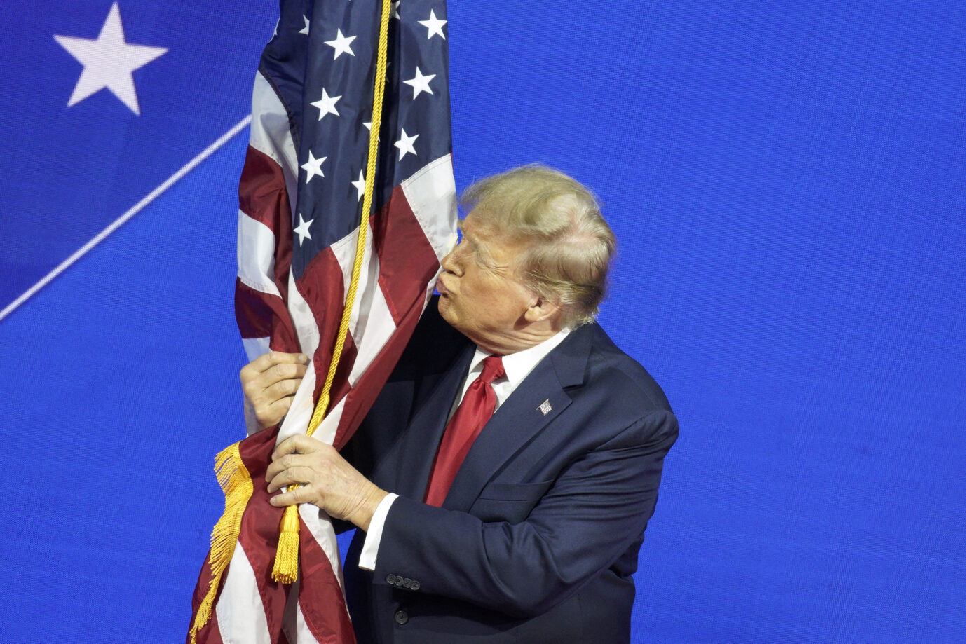 Donald Trump umarmt bei einem Treffen konservativer Politiker die US-Fahne. Seine Chancen steigen, erneut US-Präsident zu werden.