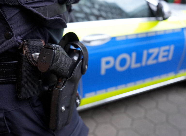 Ein Beamter vor einem Polizeiauto: 42jähriger Spanier in Hamburg festgenommen.