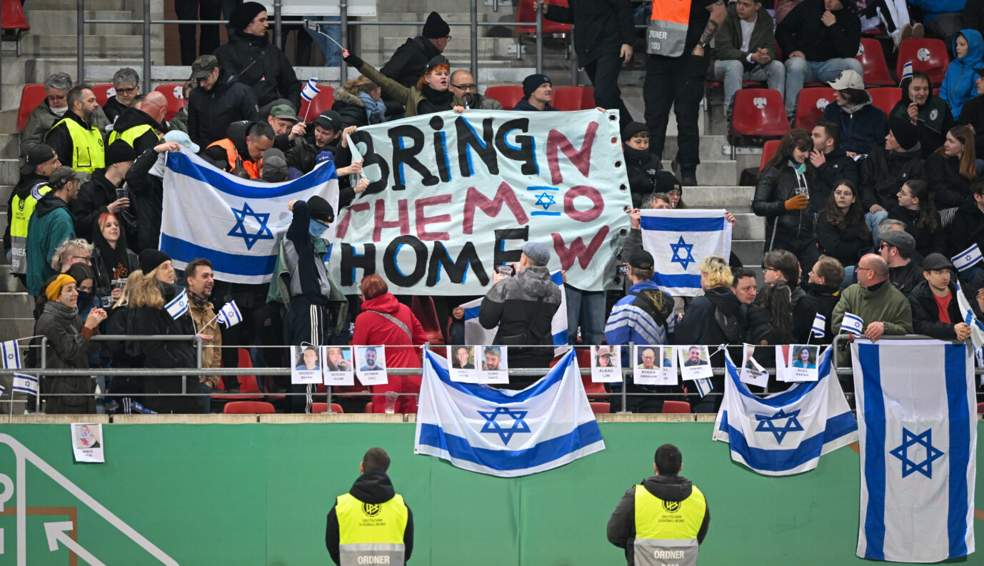 „Bringt sie jetzt nach Hause“: Wegen dieses Plakats ließ der DFB den Block der Israel-Fans stürmen.