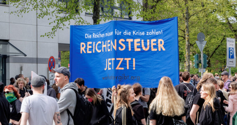 Demonstranten tragen auf einer1.Mai-Kundgebung ein Transparent mit der Aufschrift " Die Reichen müssen für die Krise zahlen! Reichensteuer jetzt! ". Kommt die Vermögenssteuer?