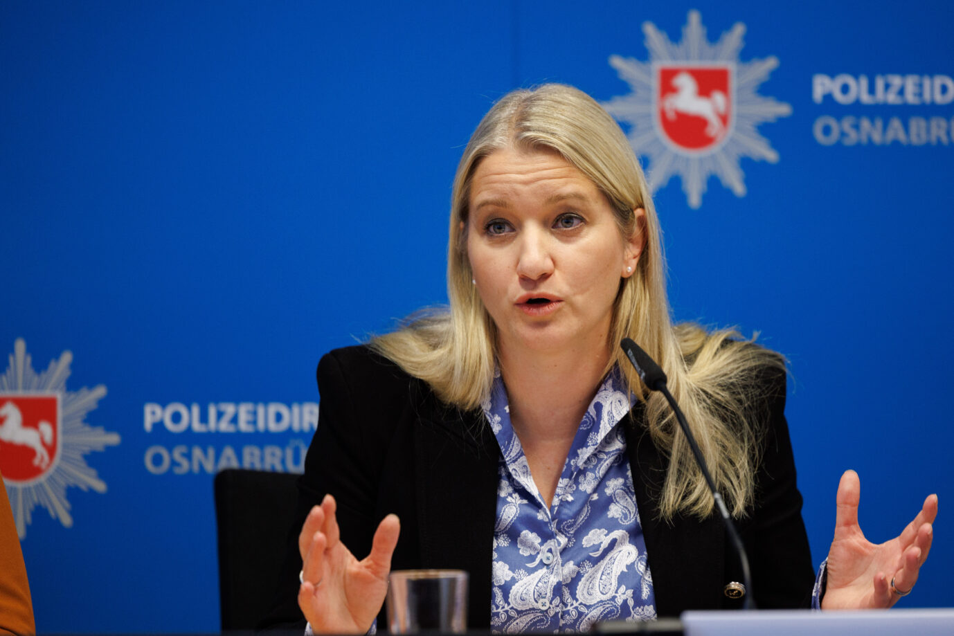 Die niedersächsische Justizministerin Kathrin Wahlmann (SPD) gestikuliert auf einer Presseveranstaltung. Im Hintergrund ist das Logo der niedersächsischen Polizei zu sehen. Sie fordert härtere Strafen für Vergewaltiger und Totschläger.