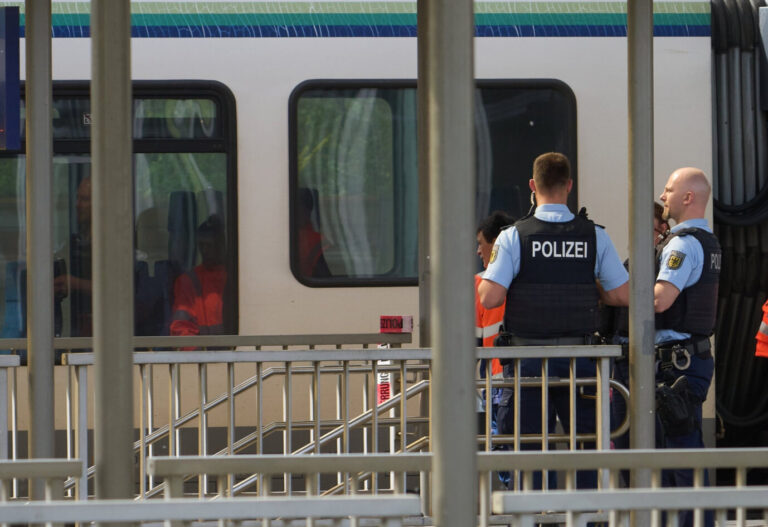 Zwei Männer in Polizeiuniformen sichern einen Zug in Niederlahnstein. Zuvor hatte hier ein Sudanese einen Mitfahrer mit einem Messer angegriffen