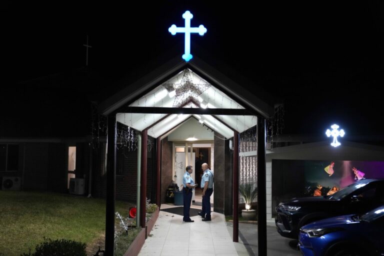 Messerangriff: Zwei Polizisten in Uniformen der australischen Polizei stehen im Eingang einer assyrisch-orthdoxen Kirche in Sydney.