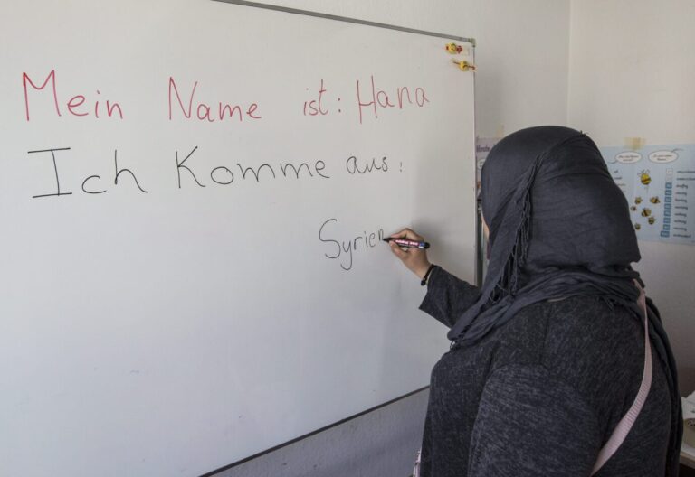 DEUTSCHLAND, BONN - MÄRZ 16: Deutschunterricht für Flüchtlinge und Asylsuchende in der Erstaufnahmeeinrichtung in der Ermekeilkaserne in Bonn. Muslima aus Syrien schreibt ihr Herkunftsland Syrien auf eine Tafel. Islamismus an deutschen Schulen ist ein wachsendes Problem.
