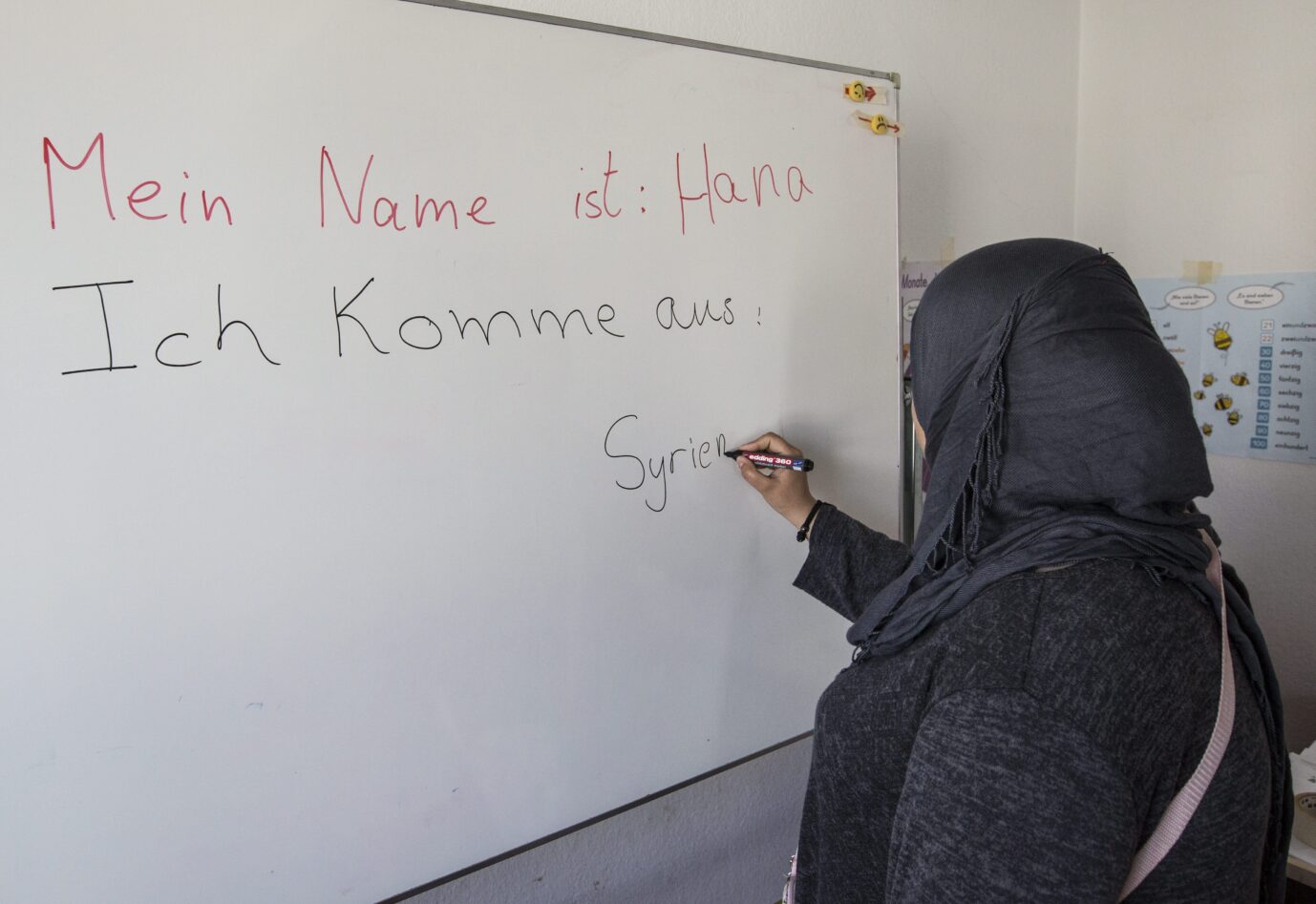  Deutschunterricht für Flüchtlinge und Asylsuchende in der Erstaufnahmeeinrichtung in der Ermekeilkaserne in Bonn. Muslima aus Syrien schreibt ihr Herkunftsland Syrien auf eine Tafel. Islamismus an deutschen Schulen ist ein wachsendes Problem.