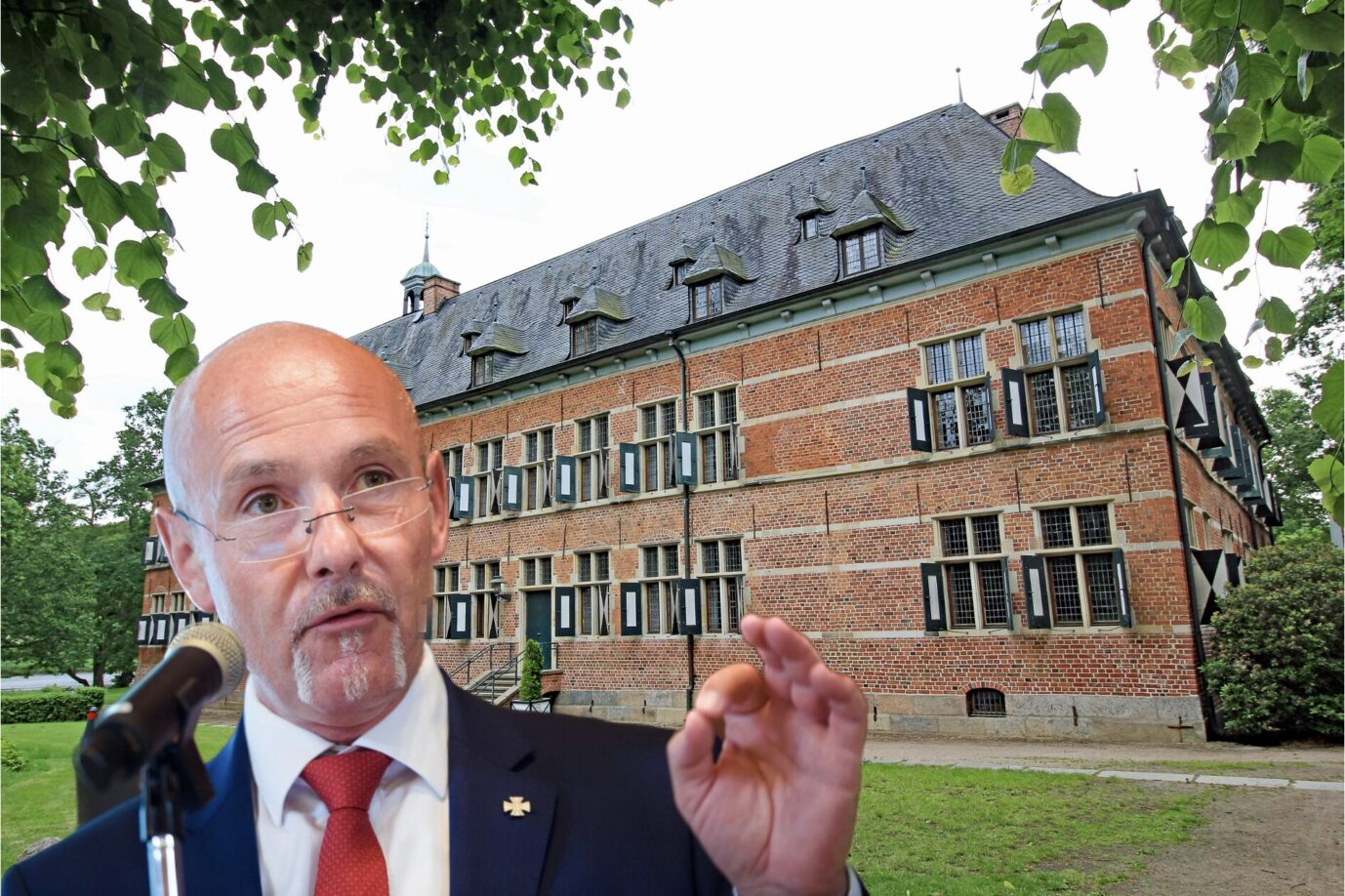 Der Vorsitzende des Landesverbandes der AfD-Schleswig-Holstein, Kurt Kleinschmidt macht die "Okay"-Geste, im Hintergrund ist das Schloß Reinbek zu sehen