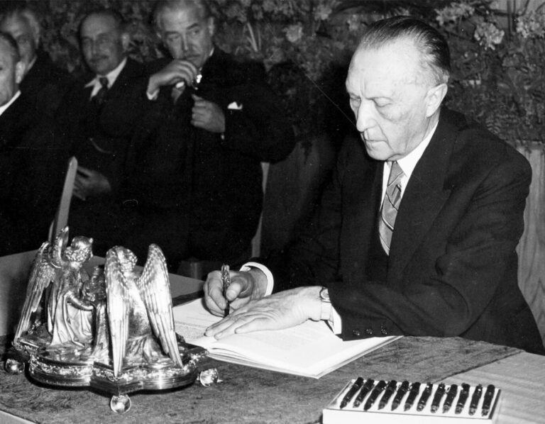 Der Präsident des Parlamentarischen Rates, Konrad Adenauer, unterzeichnet das Grundgesetz.