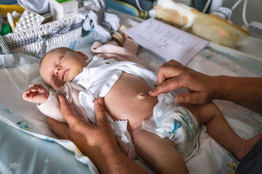 Das Bild zeigt einen Säugling, der von einer Hebamme gepflegt wird. Geburtenraten sinken in Deutschland seit Jahren, immer weniger Kinder werden geboren.