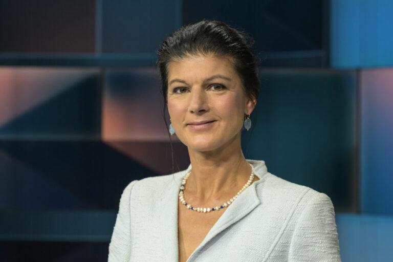 Die Vorsitzende des BSW, Sahra Wagenknecht trägt einen himmelblauen Blazer und lächelt freundlich in eine Kamera