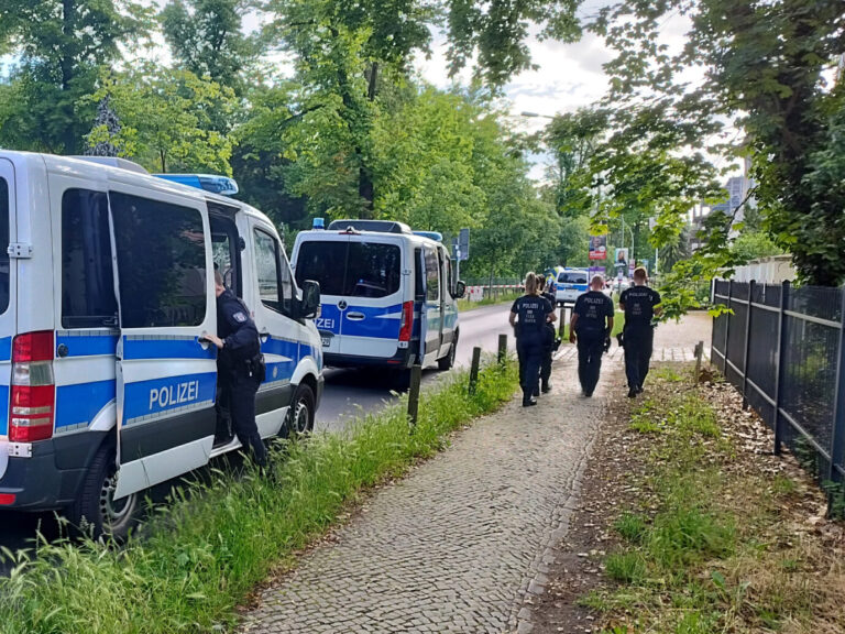 Polizisten gehen am abgesperrten Tatort in der Potsdamer Geschwister-Scholl-Straße entlang. Ein Wachmann in einer Gemeinschaftsunterkunft für Geflüchtete ist schwer verletzt worden.