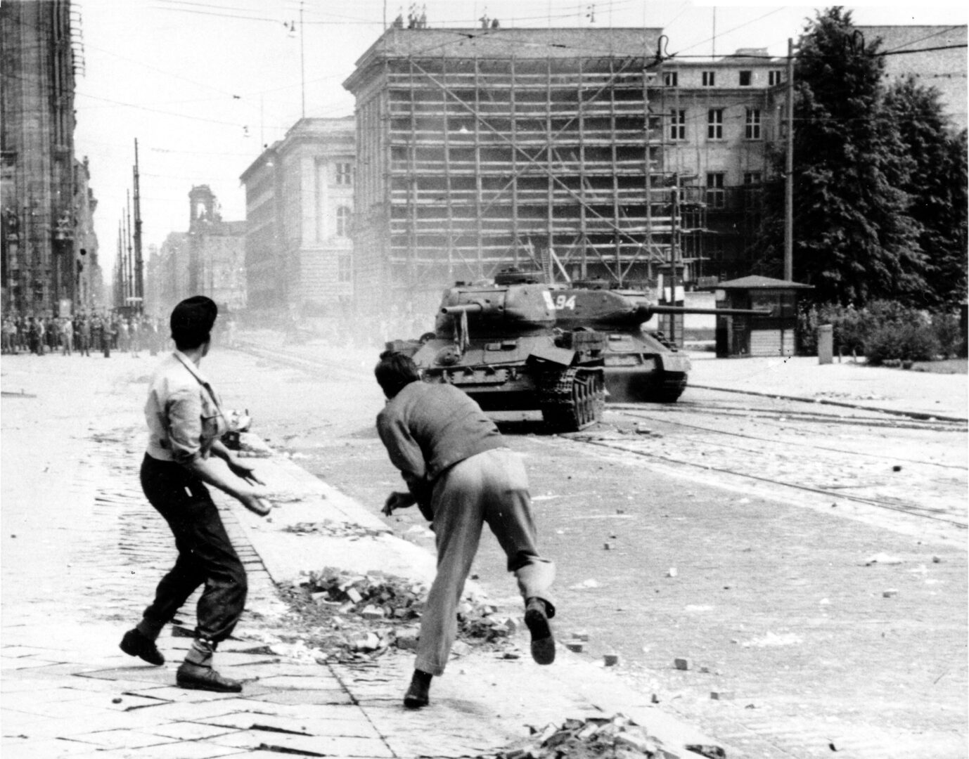 Zwei Demonstranten werfen am 17. Juni 1953 Steine auf sowjetische Panzer.