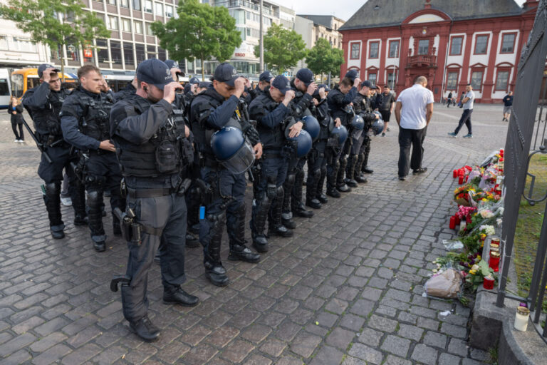 Minuten nach dem Bekanntwerden seines Todes trauern Polizisten auf dem Marktplatz in Mannheim um ihren getöteten Kollegen. Der Polizist war hier von einem Mann mit einem Messer niedergestochen und lebensgefährlich verletzt worden. Nach dem Messermord an dem jungen Polizisten in Mannheim fordern Politiker und Verbände Messerverbotszonen. Dabei bemerkt keiner, daß der Tatort bereits eine Messerverbotszone ist. Polizisten trauern auf dem Mannheimer Marktplatz ihrem ermordeten Kollegen: Politiker planen nun neue Messerverbotszonen Foto: picture alliance/dpa | Boris Roessler