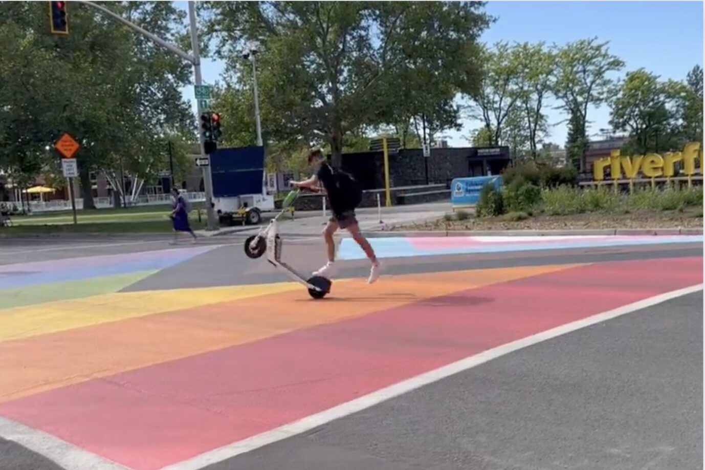 Ein Jugendlicher fährt mit einem Roller über den Regenbogen-LGBTQ-Zebrastreifen in Spokane, Washington