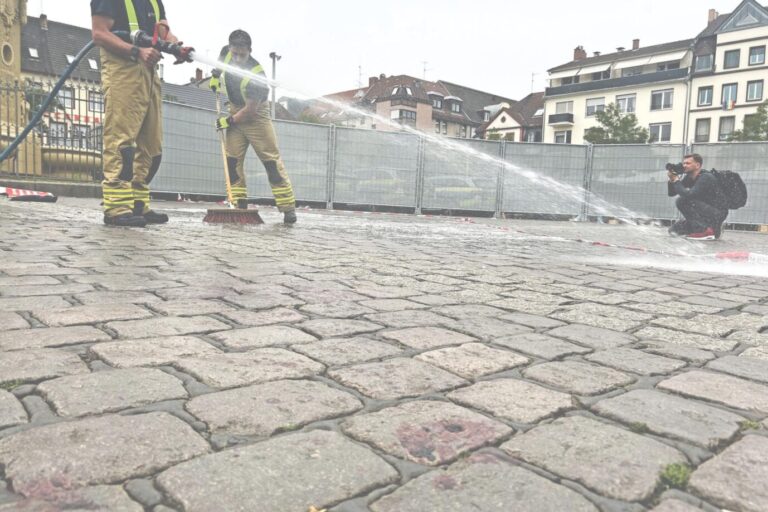 Mitarbeiter der Feuerwehr wischen die Blutspuren vom Tatort in Mannheim weg.