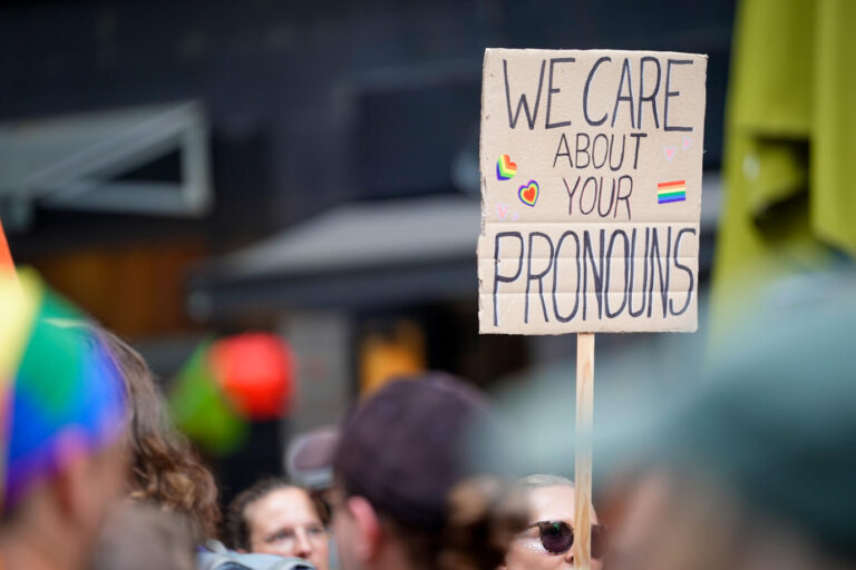 Symbolbild zur Diskussion des Gendersternchens mit Demonstrationsschild mit der Aufschrift „we care about your Pronouns“ – wir legen Wert auf eure Pronomen – am Christopher Street Day der Demonstration CSD 2023 Köln einer Veranstaltungsreihe, die sich weltweit für die Rechte und Gleichstellung von LGBTQ+-Menschen einsetzt. Ein Schild mit der Aufschrift „we care about your Pronouns“ bei einer Schwulenparade (Symbolbild): In Lübeck werden Millionen für ein „Sexdiversity“-Projekt ausgegeben Foto: picture alliance / Flashpic | Jens Krick