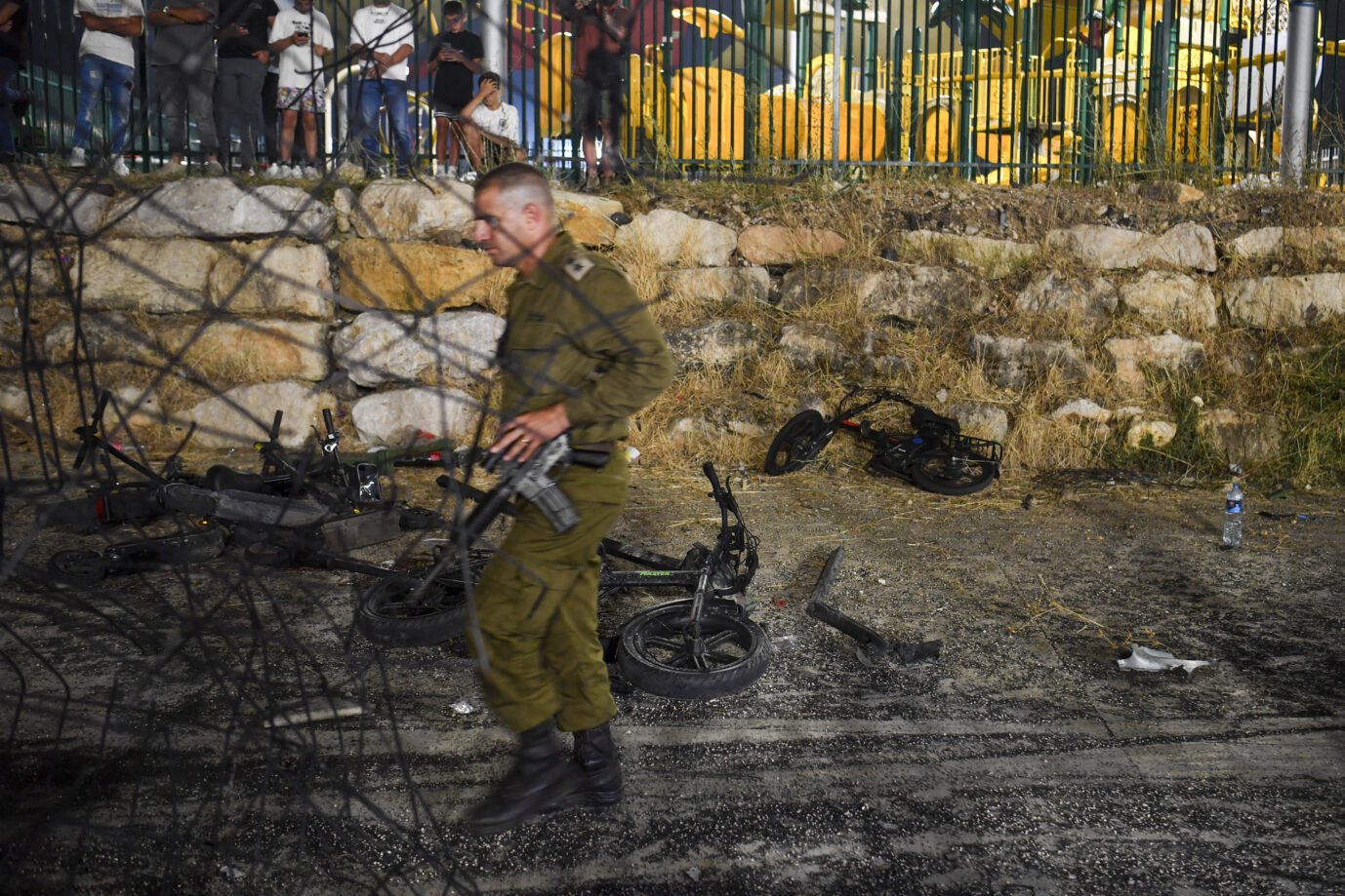 In Israel schlägt eine iranische Rakete auf einem Fußballplatz ein und tötet zwölf Kinder und Jugendliche. Gefeuert wurde sie von der Hisbollah-Miliz im Libanon. Reicht das für eine Kriegserklärung? Ein israelischer Militäroffizier geht an zerstörten Kinderfahrrädern am Ort eines Raketenangriffs in der drusischen Stadt Majdal Shams auf den israelisch kontrollierten Golanhöhen vorbei. Ein israelischer Soldat an dem Ort des Raketenangriffs: Wird Israel in den Libanon einmaschieren, um die Hisbollah-Miliz auszuschalten? Foto: picture alliance / ASSOCIATED PRESS | Gil Eliyahu