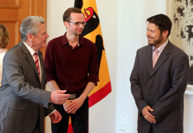 Bundespräsident Joachim Gauck (l) begrüßt am 01.08.2014 im Schloss Bellevue in Berlin Vertreter der Initiative "Salaam-Schalom" aus Berlin-Neukölln, Armin Langer und Ender Cetin (r). Die Initiative «Salaam-Schalom» setzt sich für ein Miteinander der Kulturen ein. Cetin steht nun wegen eines Graue Wölfe-Shirts in der Kritik Foto: Wolfgang Kumm dpa ++