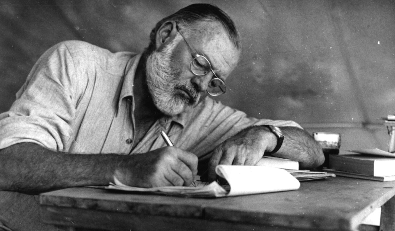Großschriftsteller Ernest Hemingway (1899–1961) beim Schreiben in einem Zeltlager in Kenia, um 1953 (Themenbild)