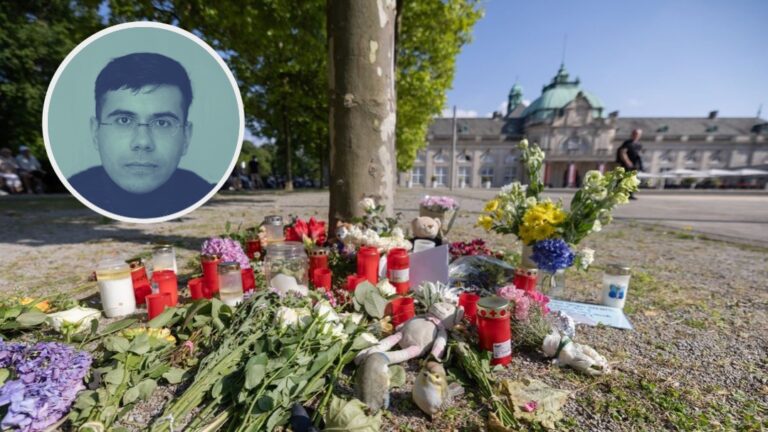 Blumen, Kerzen und handgeschriebene Trauerbekundungen stehen an einem Baum im Kurpark Bad Oeynhausen