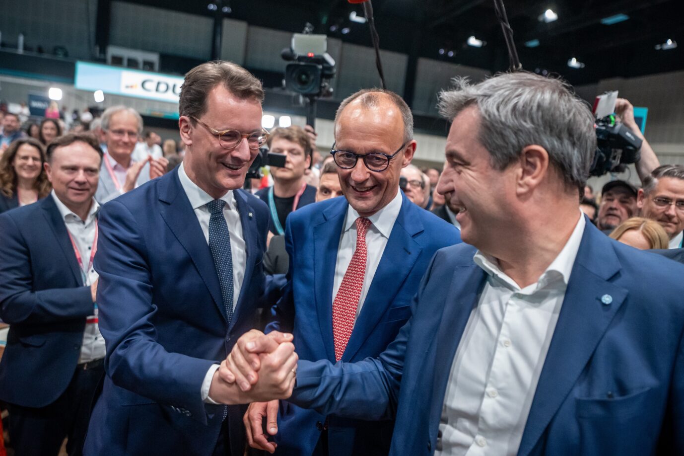 Friedrich Merz (M), CDU-Bundesvorsitzender, steht zwischen Hendrik Wüst (l, CDU), Ministerpräsident von Nordrhein-Westfalen, und Markus Söder, (CSU), Ministerpräsident von Bayern, beim CDU-Bundesparteitag. Auf dem Programm steht die Verabschiedung des neuen Grundsatzprogramms der Union. Der Umgang mit der AfD spaltet die Parteibasis.