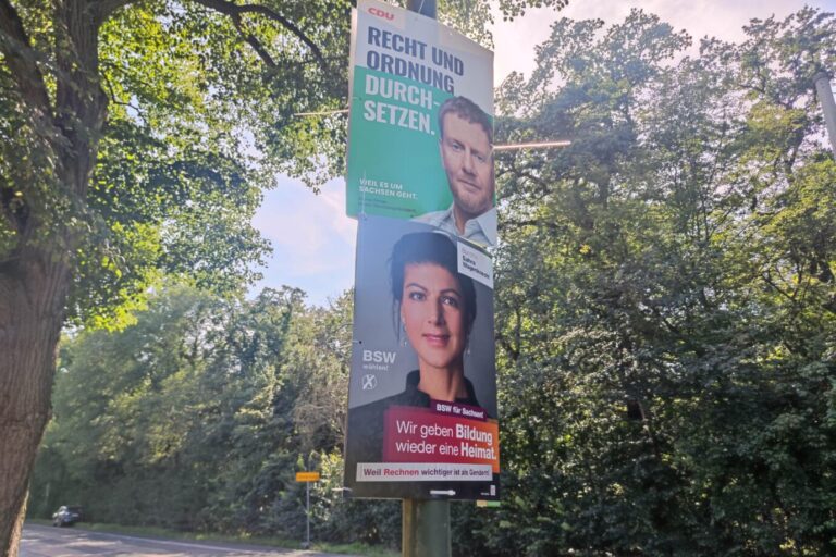 Wahlplakate zur Landtagswahl: CDU-Wahlplakat mit Michael Kretschmer ("Recht und Ordnung durchsetzen"), darunter BSW mit Sahra Wagenknecht