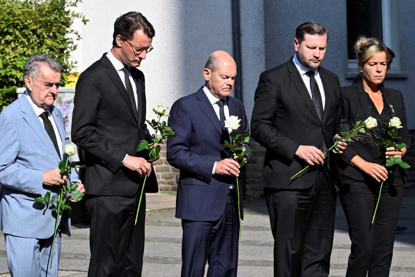 NRW-Innenminister Herbert Reul, -Ministerpräsident Hendrik Wüst (beide CDU), Solingens Bürgermeister Tim Kurzbach und Kanzler Olaf Scholz (beide SPD)legen Blumen am Ort des Anschlags in Solingen nieder.