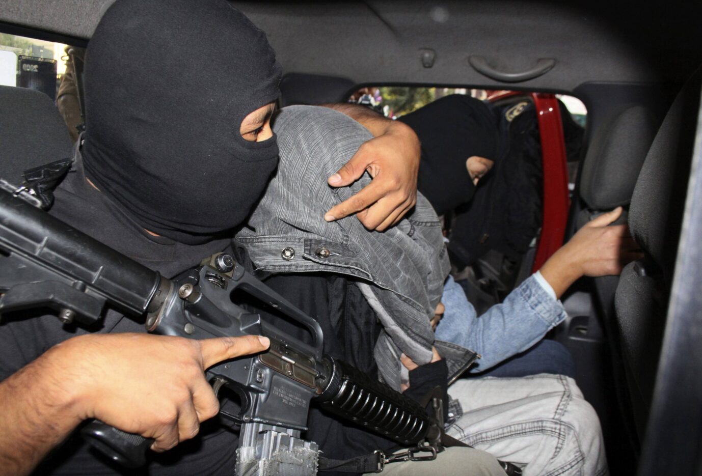 A police officer drapes a jacket over the head of a suspect believed to be Edgar Jimenez (C), also known as "El Ponchis", after escorting him out of a juvenile court in Cuernavaca December 5, 2010. Mexican soldiers captured Jimenez, a 14-year-old U.S. citizen suspected of being a drug gang hitman as he attempted to travel to the United States. ... Festnahme eines Kartell-Mitglieds in Mexio (Symbolbild): Gewalt schwappt in die USA Foto: picture alliance / REUTERS | STRINGER/MEXICO