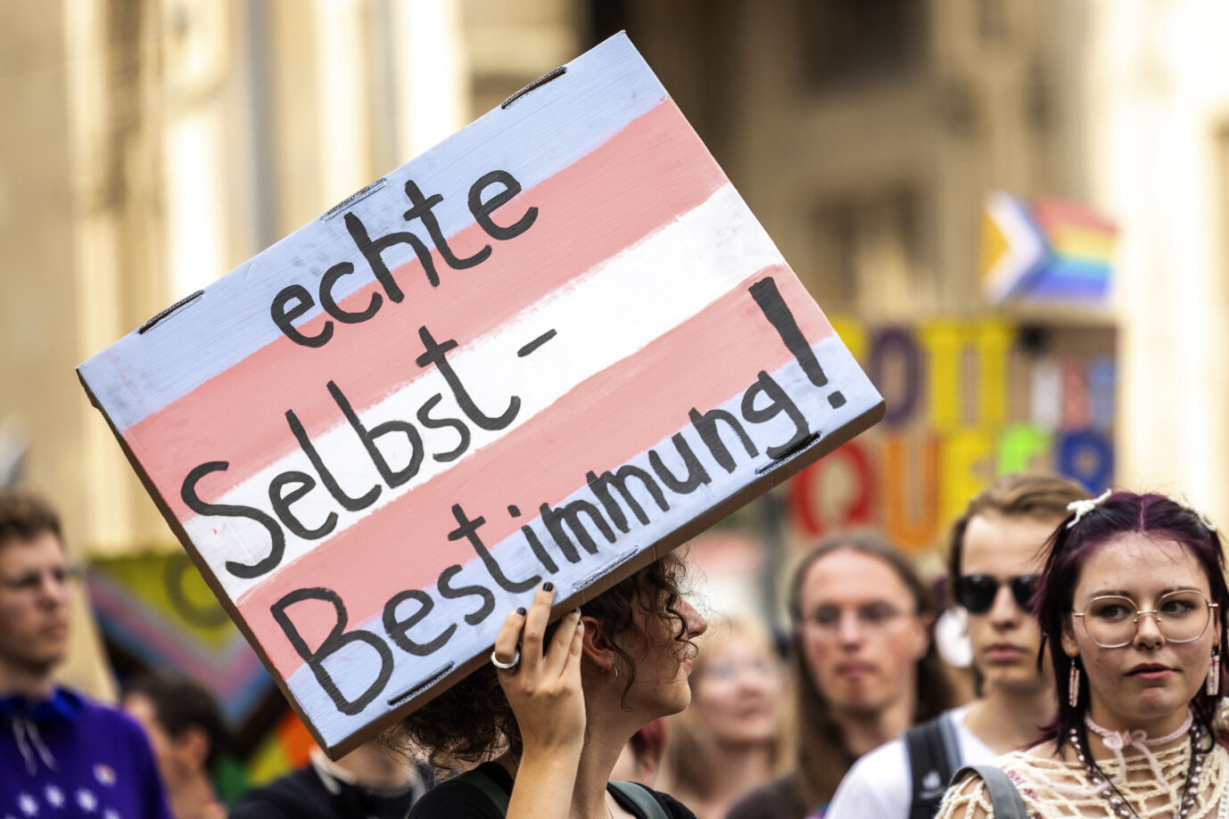 Ein Schild mit der Transsexuellen-Flagge als Hintergrund auf dem Christopher-Street-Day in Erfurt: Seit dem Inkrafttreten des Selbstbestimmungsgesetzes ist die Anzahl der Anträge auf Geschlechtseintragsänderung gestiegen. (Symbolbild)