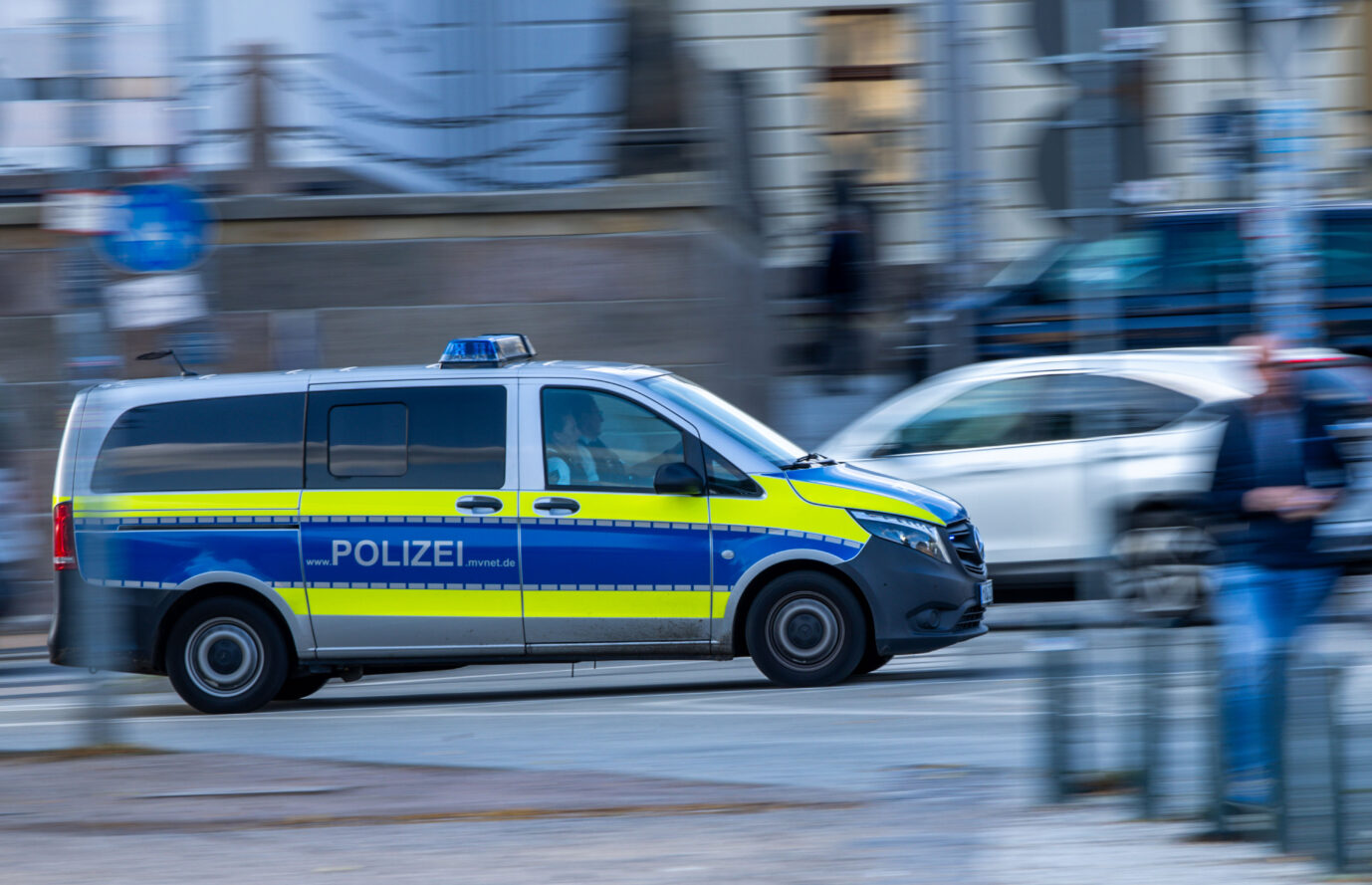 Ein blauer Bus der deutschen Polizei rast über eine Straße zu einem Einsatz – möglicherweise zur Essener Elisabeth-Klinik, wo mutmaßliche Clan-Mitglieder das Krankenhauspersonal attackierten