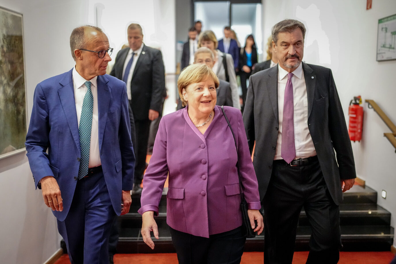 Angela Merkel läßt sich von CDU-Chef Friedrich Merz (links) und CSU-Chef Markus Söder in den Festsaal bringen.