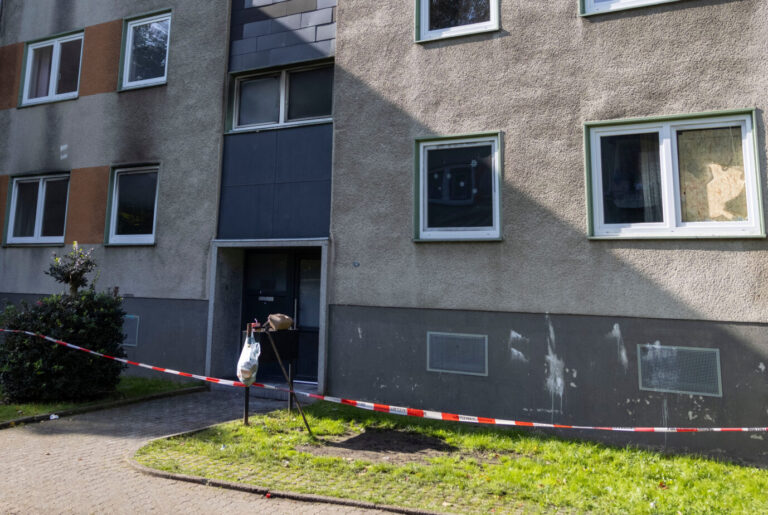 Ein tristes graues Wohnhaus, davor flattert Polizeiabsperrungsband. An den Fenstern sind Brandspuren zu sehen. Ein Syrer hat hier, in Essen, einen Brand-Angriff verübt