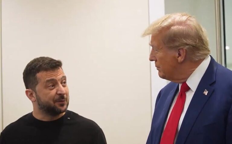 Der ukrainische Präsident Wolodymyr Selenskij und der ehemalige US-Präsident Donald Trump schauen sich gegenseitig freundlich ins Gesicht. Selenskij trägt einen olivgrünen Pullover, Trump seine typische rote Krawatte