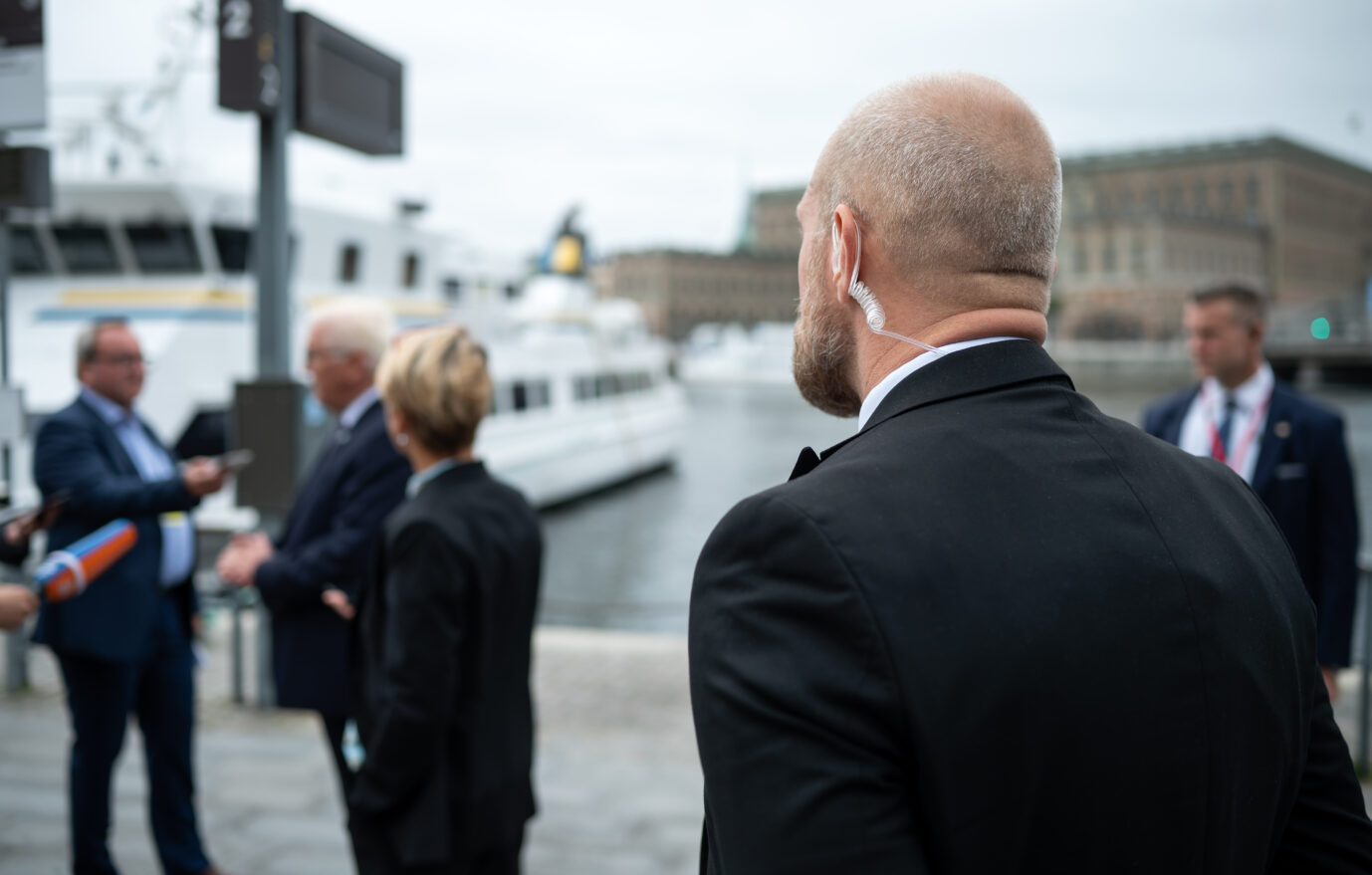 Ein Personenschützer des Bundeskriminalamts (BKA) bewacht vor einem Hotel in Stockholm Bundespräsident Frank-Walter Steinmeier, der gerade ein Pressestatement gibt. Bundespräsident Steinmeier und seine Frau sind auf Einladung des schwedischen Königspaares zu einem dreitägigen Staatsbesuch in Schweden. Viele Politiker bekommen Polizeischutz