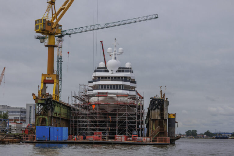 Ein großes Schiff, mutmaßlich ein Kreuzfahrtschiff, steht in der Werft in Bremerhaven im Wasser. Gerüste umgeben es, Kräne ragen davor auf. Gewerbe und Firmen, die sich auf den Bau von Schiffen spezialisieren hatten im Juli ein kleines Hoch. Die Industrie leidet.