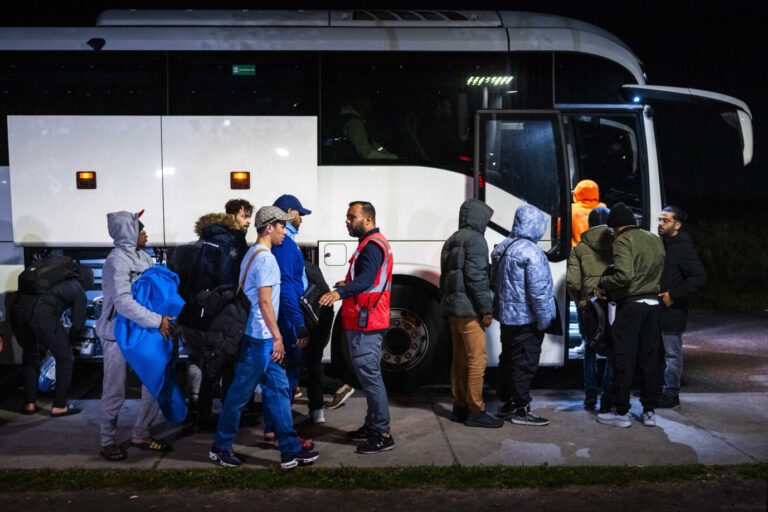 Eine Gruppe von Asylbewerbern vor einem Reisebus (Symnbolbild). Heimatbesuche von Asylbewerbern fanden seit 2023 hundertfach statt