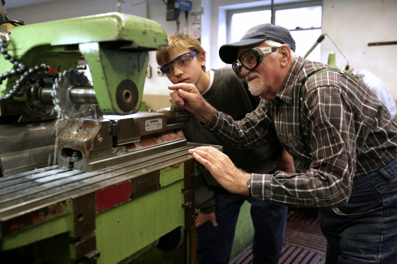 Ein berufstätiger Senior und ein Azubi: Auch in der Industrie werden Rentner dringend gesucht. (Themenbild)