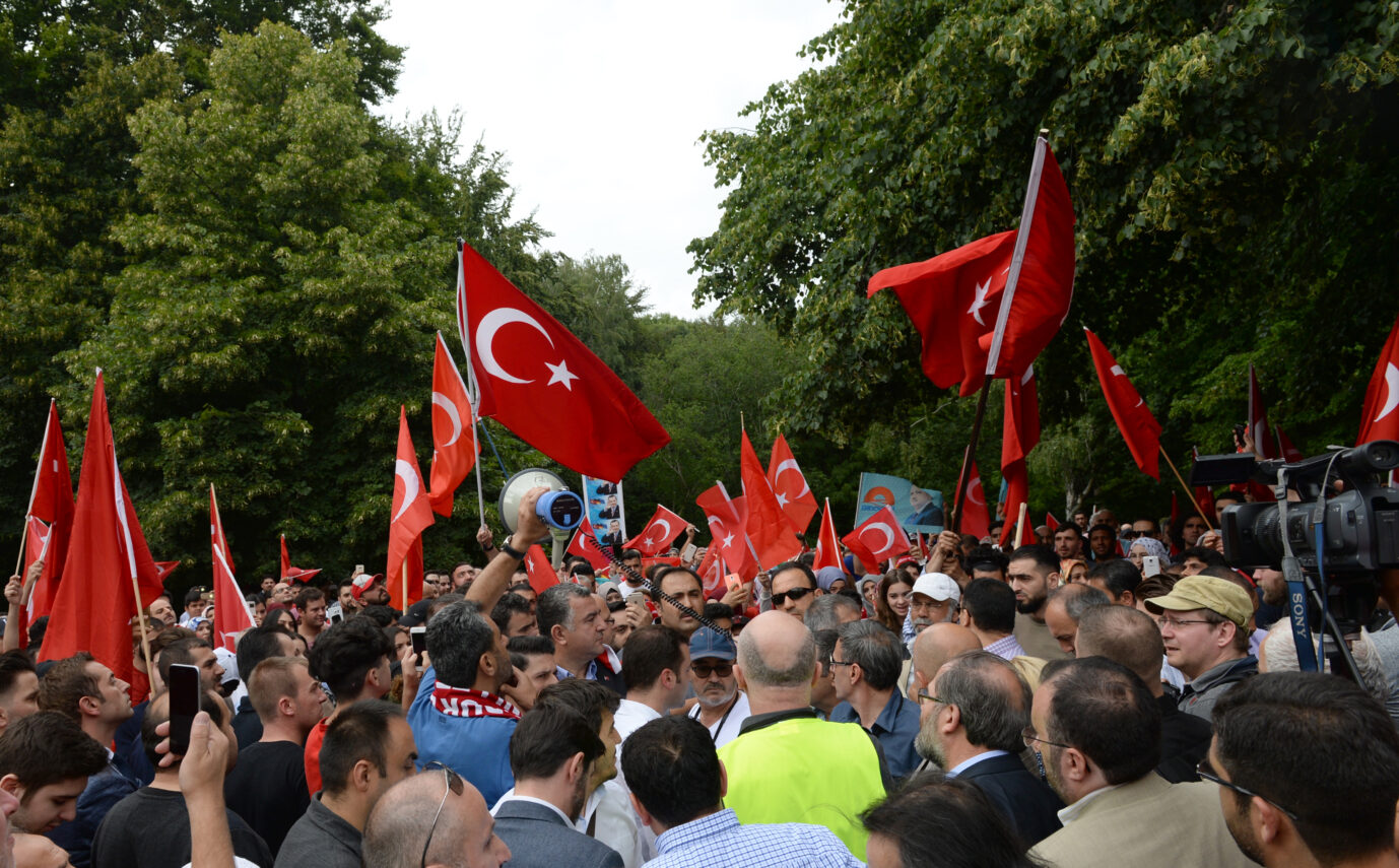 Fethullah Gülen ist tot. Doch sein Erbe lebt fort. Hierzulande zählen Tausende zu seinen Anhängern. Die Gülen-Bewegung wird nicht nur in Anatolien von Ankaras Geheimdienst drangsaliert. Mit Auswirkungen auf Deutschland. Demonstranten stehen am 16.07.2016 in Berlin mit türkischen Fahnen vor dem Botschaftsgebäude der Türkei. Nach Angaben der Polizei demonstrierten dort 500 Menschen gegen den Putschversuch des türkischen Militärs. Demonstranten mit türkischen Fahnen in Berlin: Druck in der Diaspora. Archivfoto 2016: picture alliance / dpa | Paul Zinken