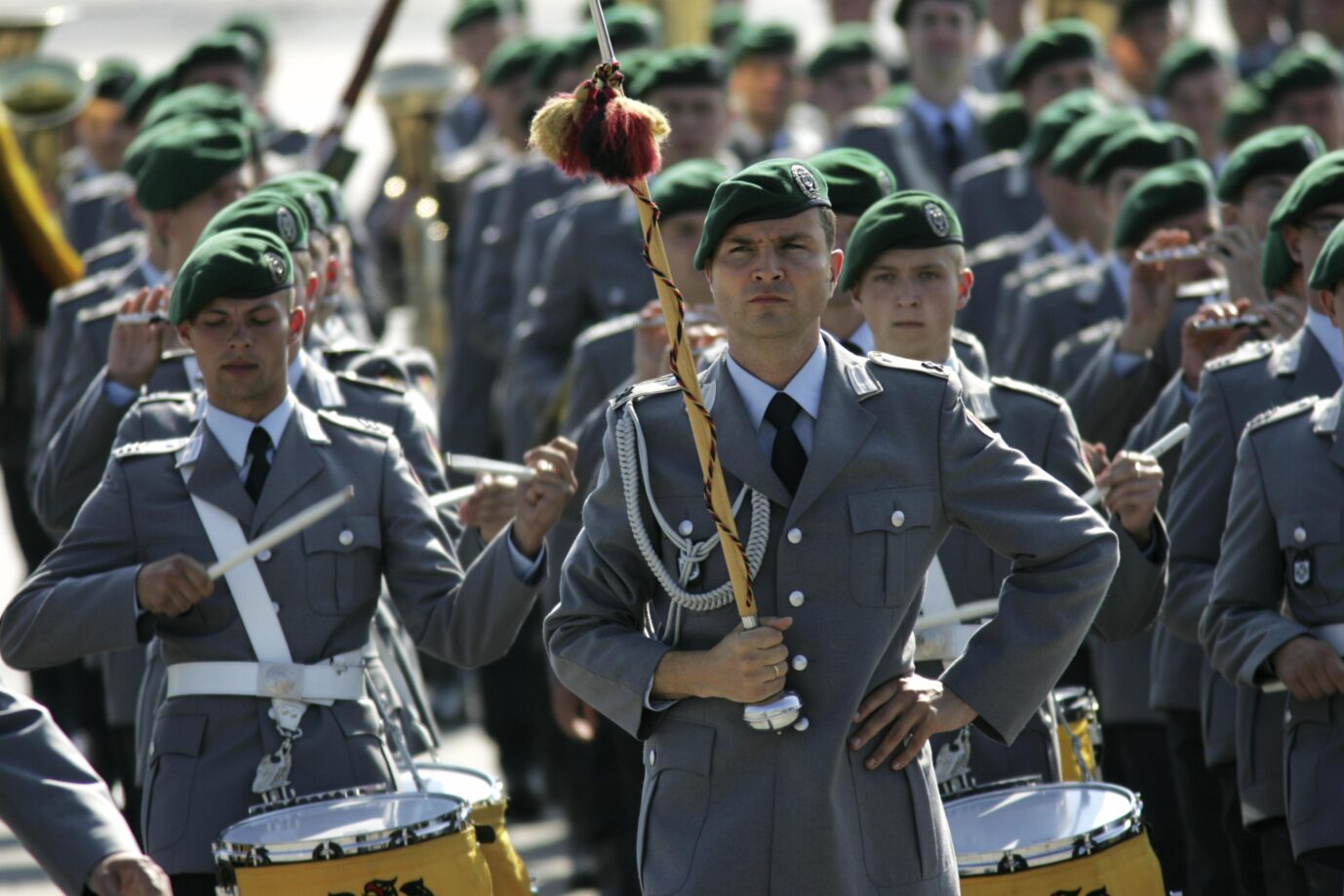 Bundeswehrsoldaten stehen in ihren grauen Ausgehuniformen in Reih und Glied. Mehrere Soldaten trommeln